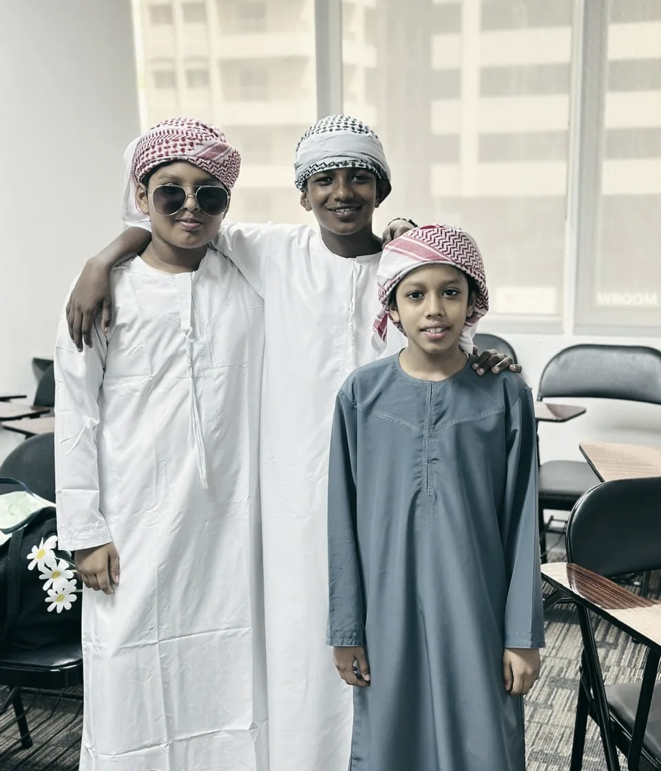 Three students together in a classroom at PHLOEM Learning in Abu Dhabi on National Day